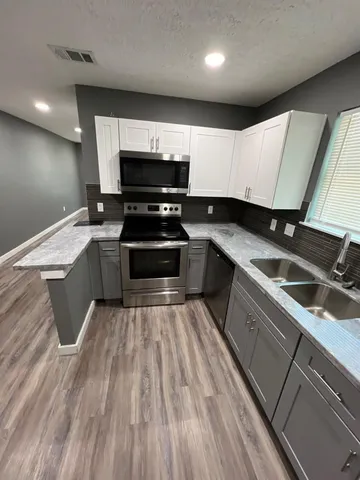 a kitchen with a sink stove and cabinets