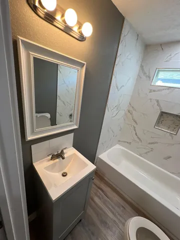 a bathroom with a sink a toilet a vanity and mirror