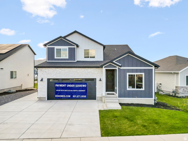 7927 Bristlecone Road, Unit 204 Eagle Mountain, UT 84005 - Photo 1 of 19 View of front of property featuring a front yard, board and batten siding, a garage, concrete driveway, and a shingled roof