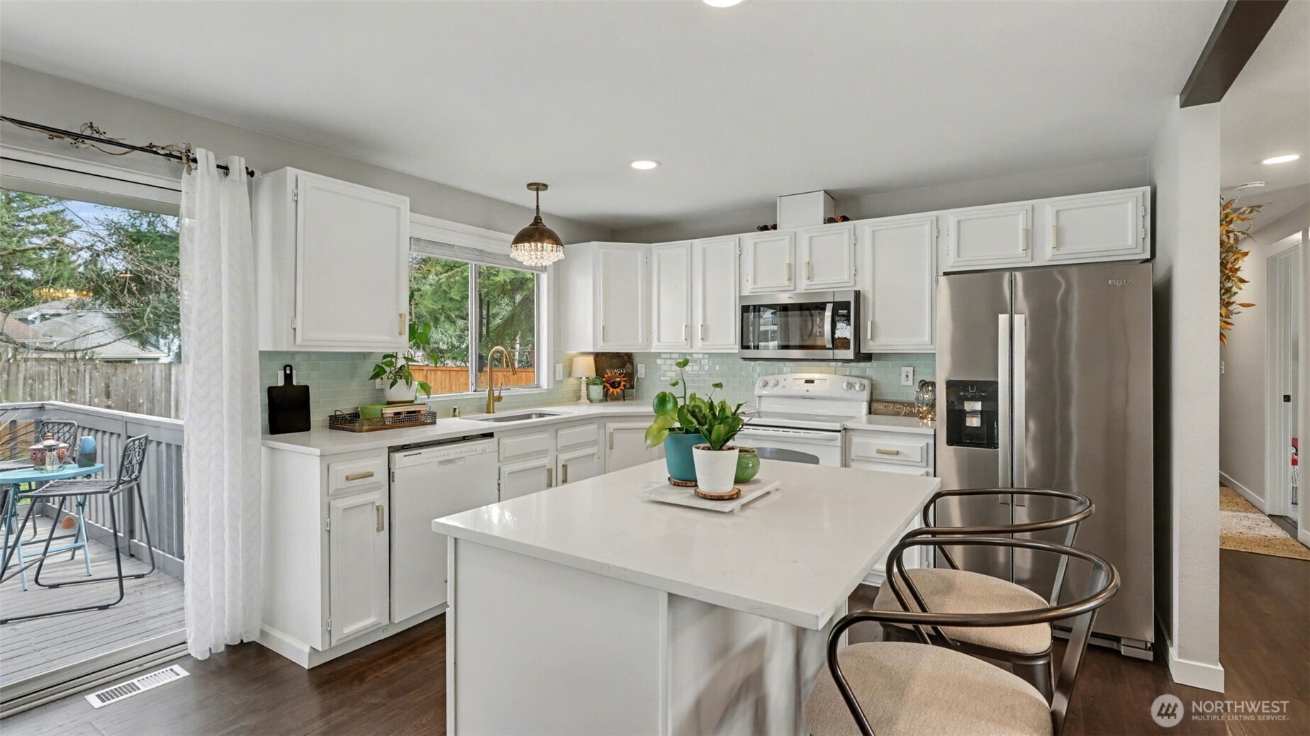 24912 168th Place Southeast Covington, WA 98042 - Photo 7 of 23 a kitchen with a refrigerator a stove a sink and white cabinets with wooden floor