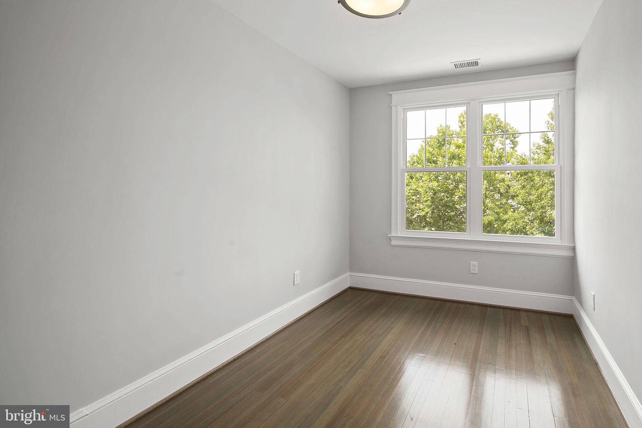 1242 Oates Street Northeast Washington, DC 20002 - Photo 11 of 47 an empty room with wooden floor and windows