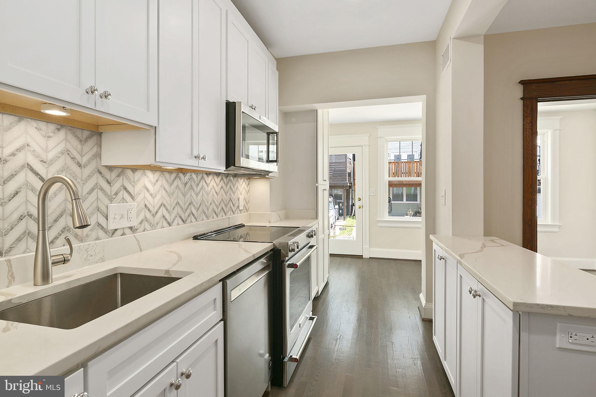 1242 Oates Street Northeast Washington, DC 20002 - Photo 22 of 47 a kitchen with a sink stove and cabinets