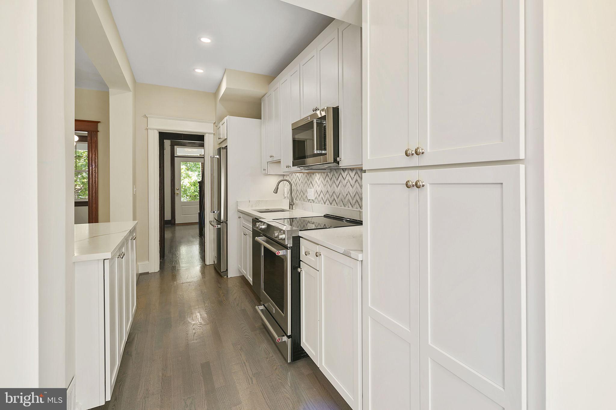 1242 Oates Street Northeast Washington, DC 20002 - Photo 23 of 47 a kitchen with stainless steel appliances granite countertop a refrigerator and a stove top oven