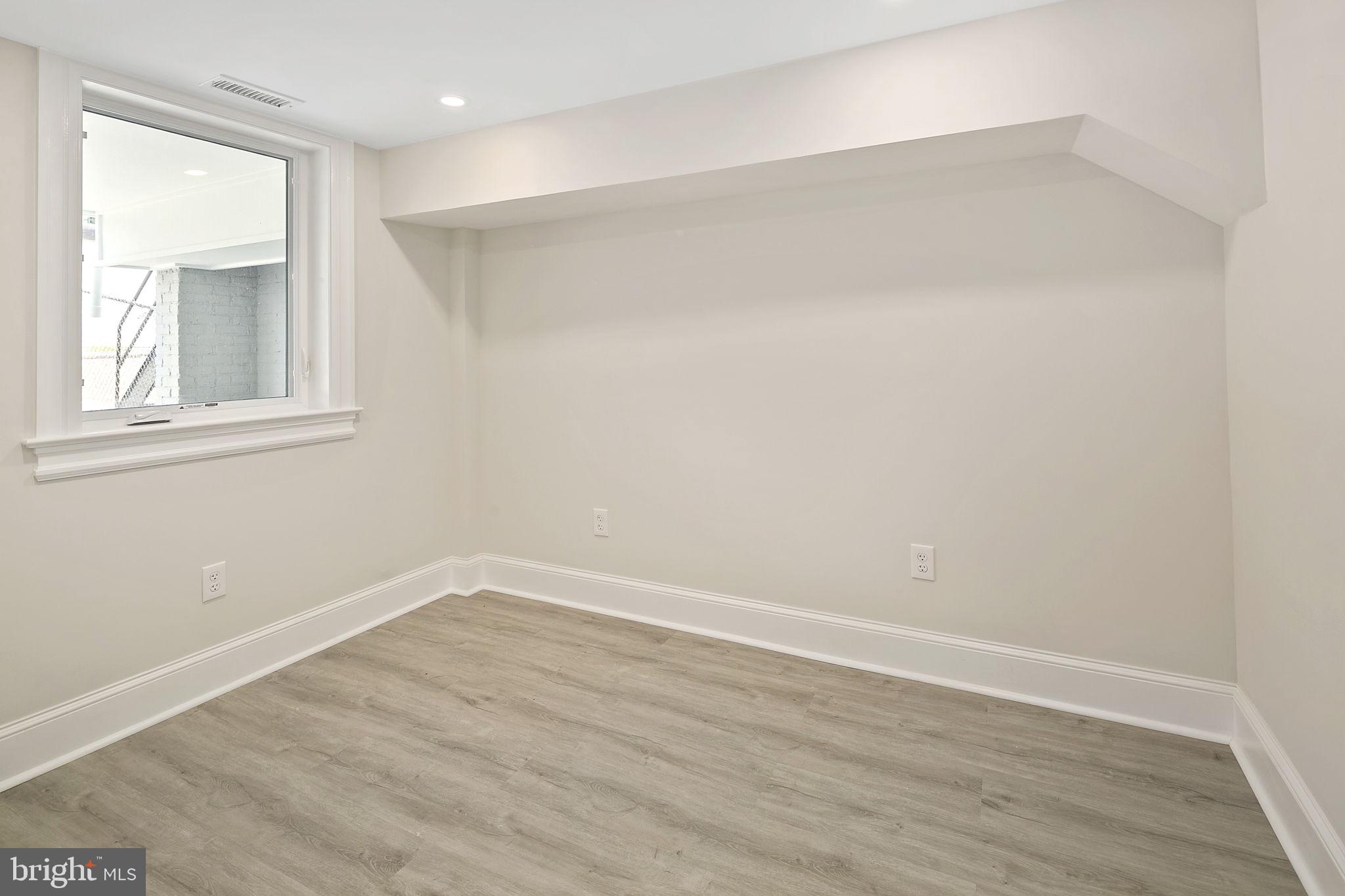 1242 Oates Street Northeast Washington, DC 20002 - Photo 31 of 47 an empty room with wooden floor and windows