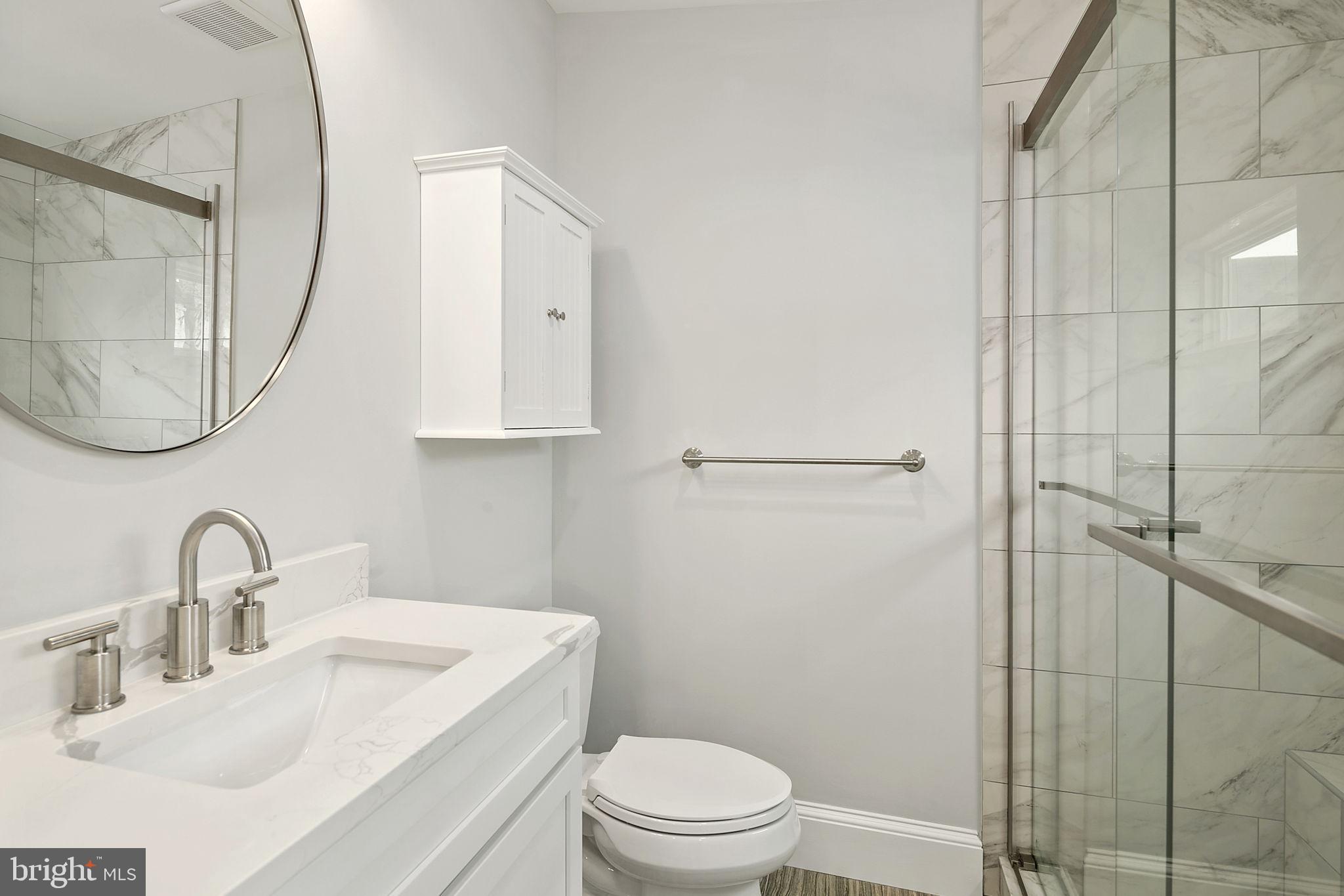 1242 Oates Street Northeast Washington, DC 20002 - Photo 4 of 47 a bathroom with a toilet sink vanity and mirror