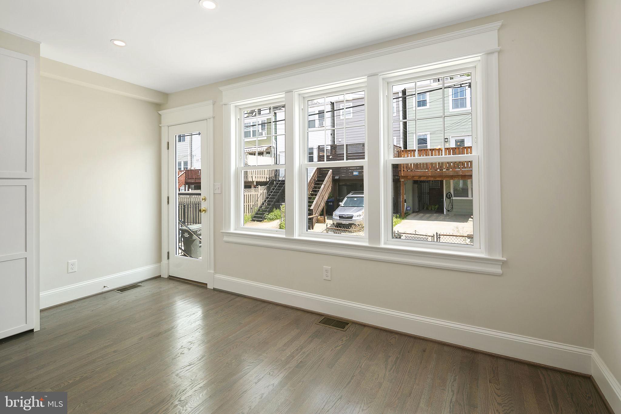 1242 Oates Street Northeast Washington, DC 20002 - Photo 9 of 47 an empty room with wooden floor and windows