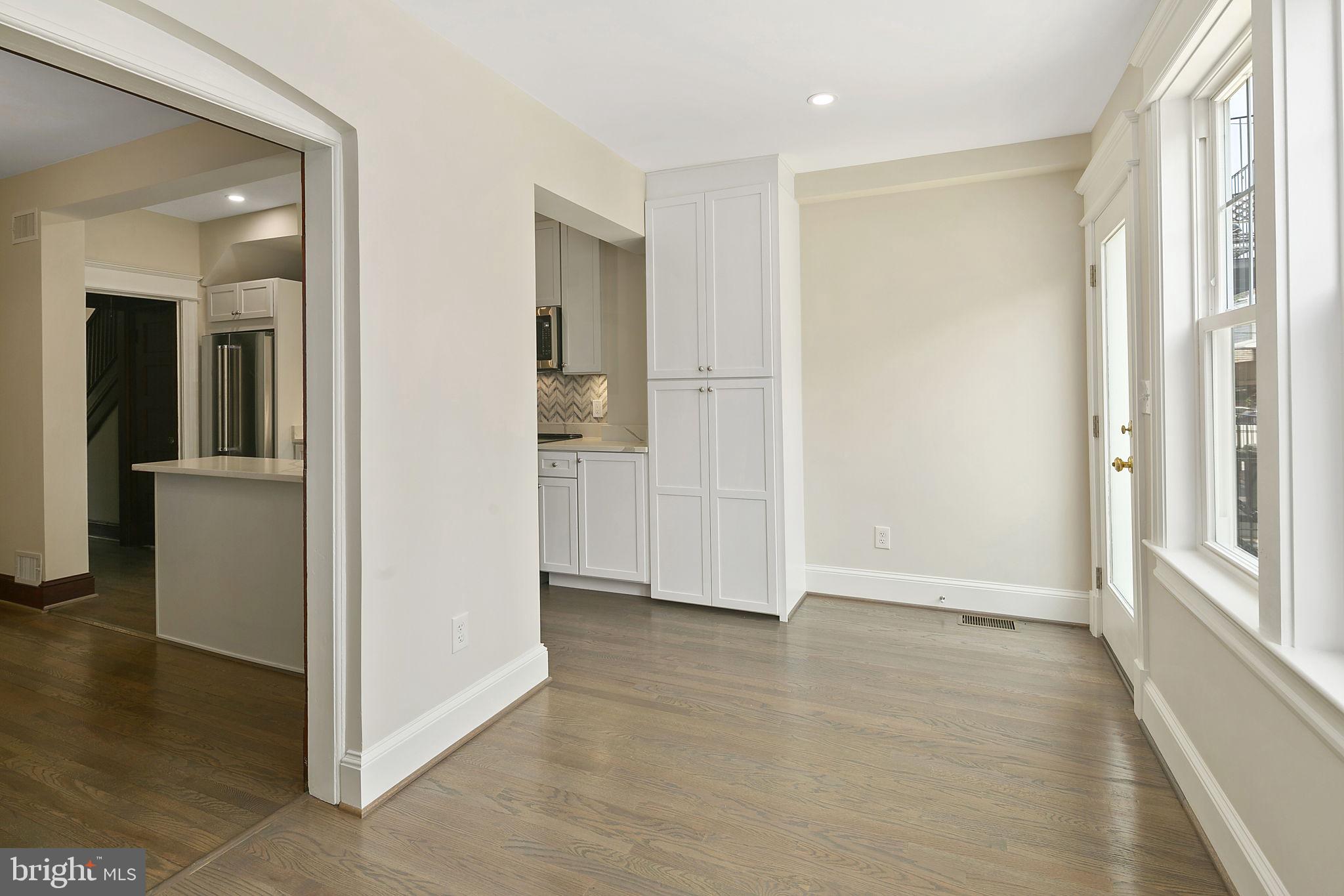 1242 Oates Street Northeast Washington, DC 20002 - Photo 10 of 47 an empty room with wooden floor mirror and windows