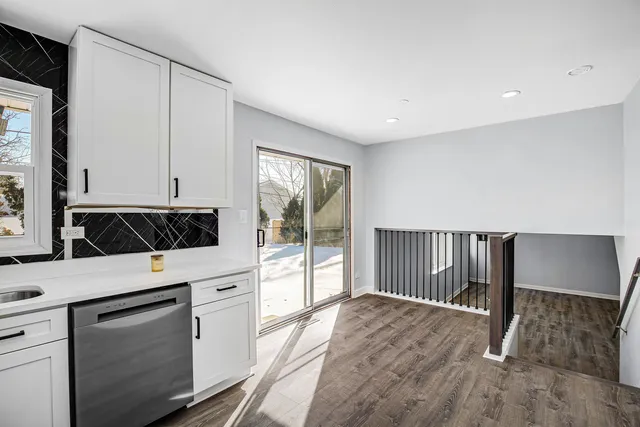 a kitchen with a refrigerator and white cabinets