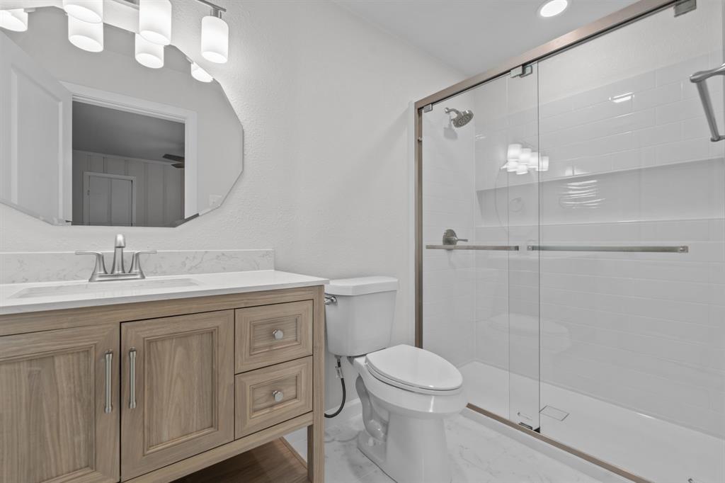 217 Clinton Drive Weatherford, TX 76086 - Photo 13 of 19 a bathroom with a granite countertop sink a toilet and a mirror
