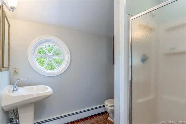a bathroom with a sink a toilet and a mirror