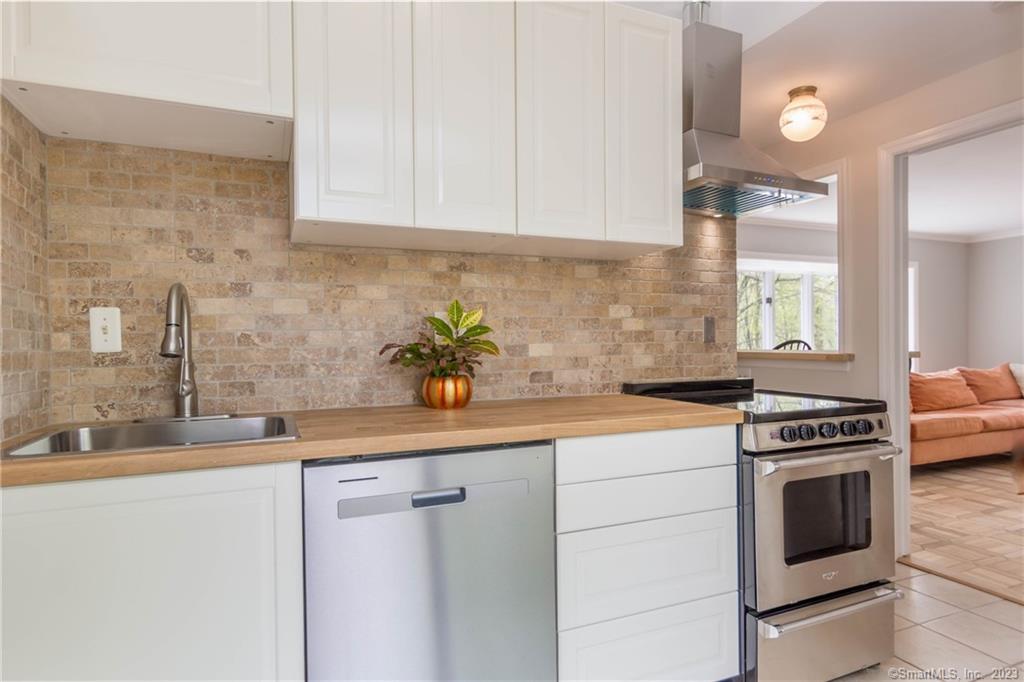 241 Maple Road Easton, CT 06612 - Photo 9 of 21 a kitchen with stainless steel appliances granite countertop a sink a stove and white cabinets