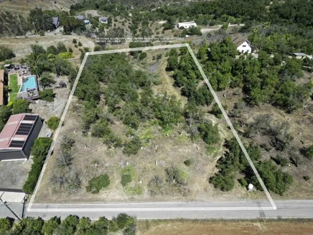 an aerial view of a residential houses with yard