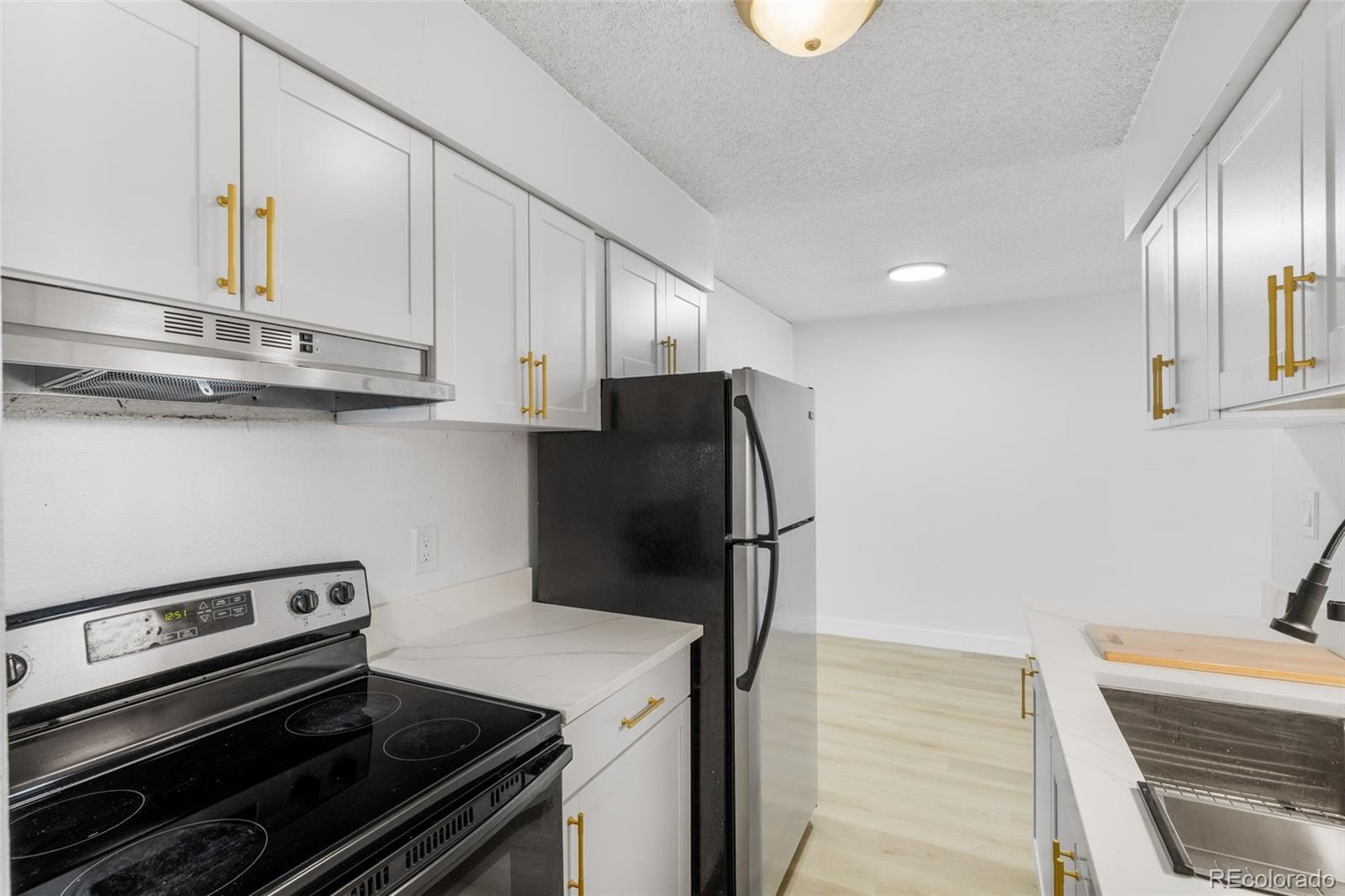 7755 East Quincy Avenue, Unit 303A5 Denver, CO 80237 - Photo 14 of 35 a kitchen with a stove and a refrigerator