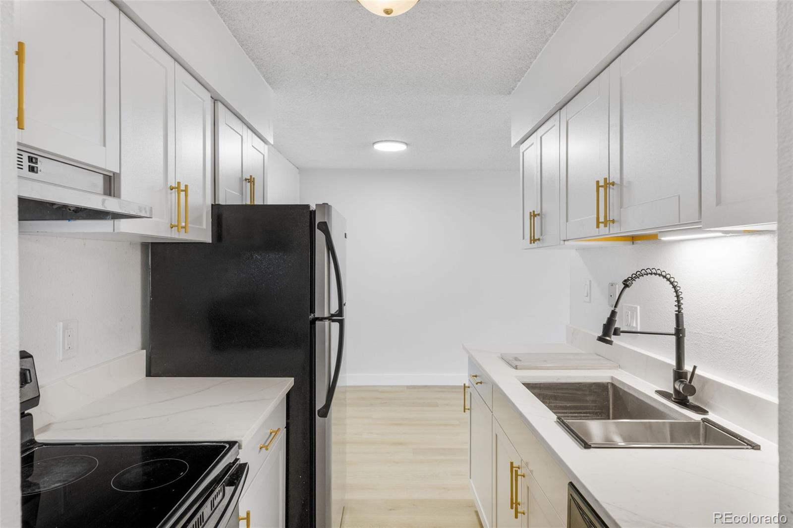 7755 East Quincy Avenue, Unit 303A5 Denver, CO 80237 - Photo 16 of 35 a kitchen with stainless steel appliances a refrigerator sink and cabinets