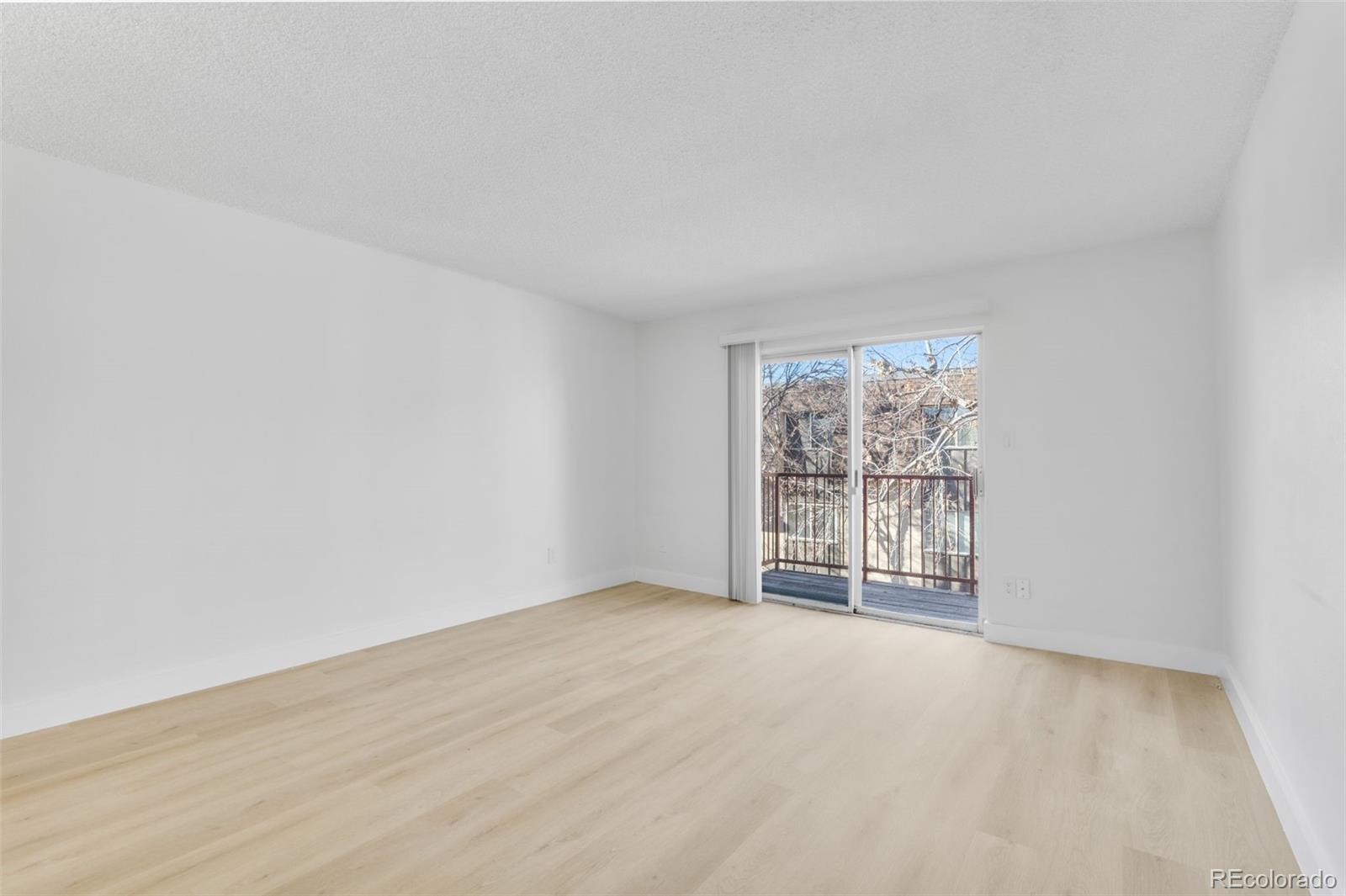 7755 East Quincy Avenue, Unit 303A5 Denver, CO 80237 - Photo 8 of 35 an empty room with wooden floor and windows