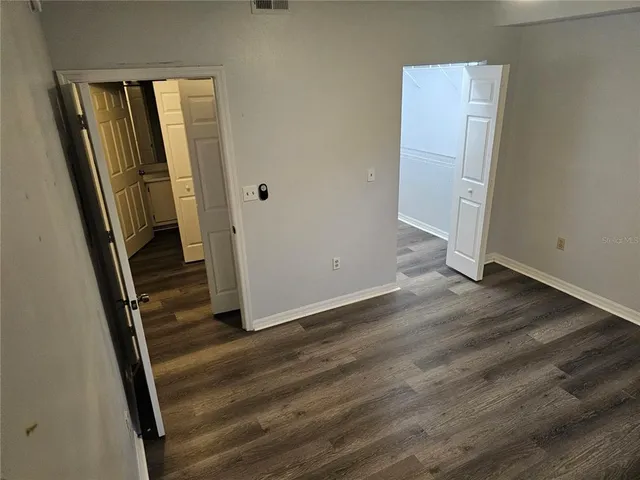 an empty room with wooden floor and closet