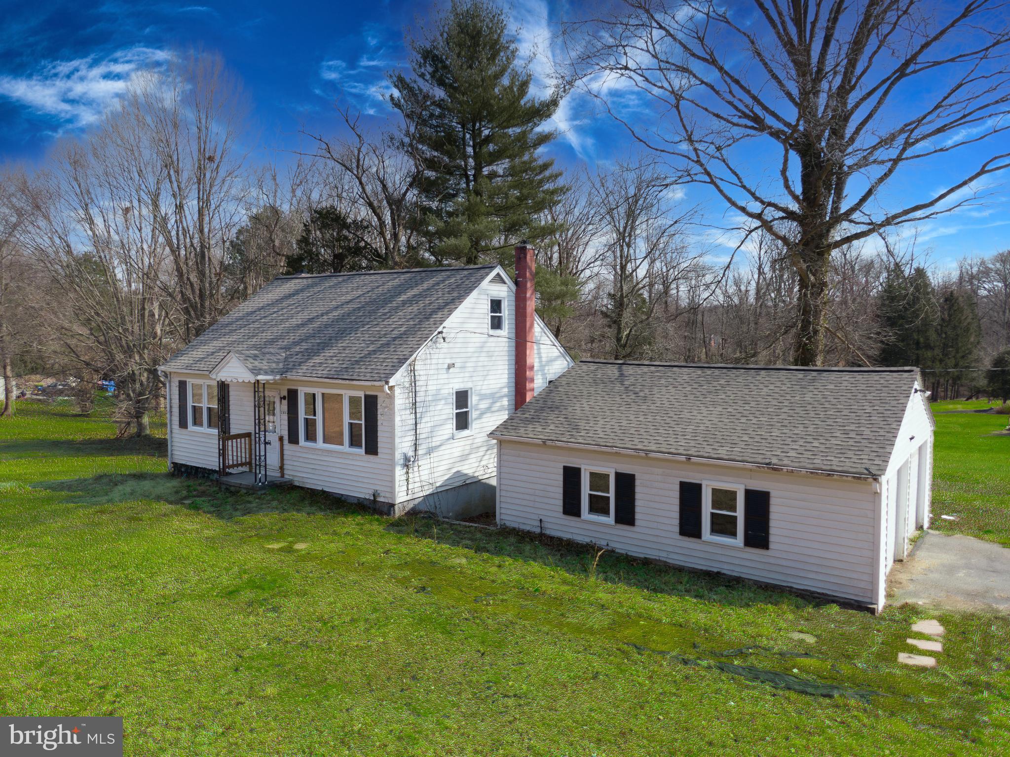 a aerial view of a house next to a big yard and large trees