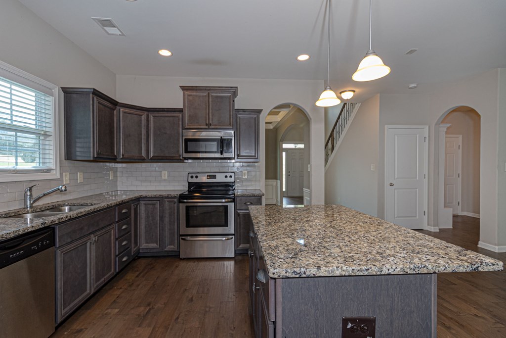 104 Pin Oak Way Hamilton, GA 31811 - Photo 10 of 41 a kitchen with kitchen island granite countertop a sink stainless steel appliances and cabinets