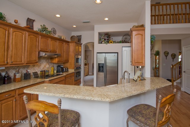 3385 Kings Road South St. Augustine, FL 32086 - Photo 11 of 36 a kitchen with stainless steel appliances granite countertop a sink refrigerator and cabinets