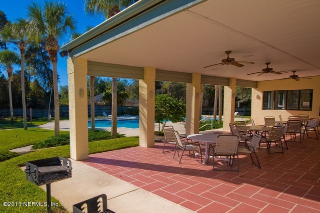 3385 Kings Road South St. Augustine, FL 32086 - Photo 35 of 36 a view of a patio with table and chairs potted plants and floor to ceiling window