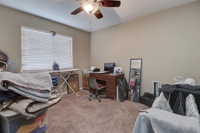 a view of a workspace with furniture and a window