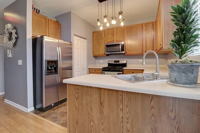 a kitchen with stainless steel appliances a refrigerator sink and microwave