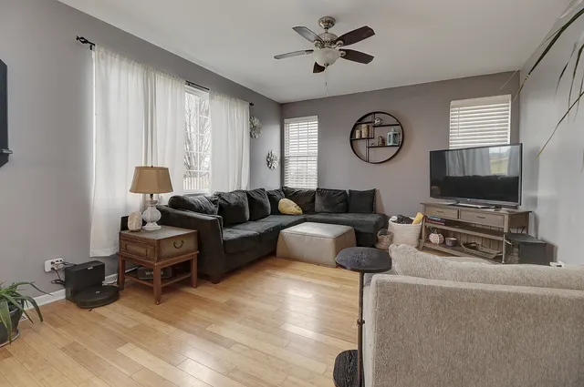 a living room with furniture a large window and a flat screen tv