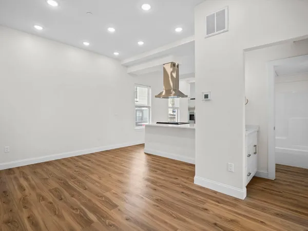 a view of empty room with wooden floor