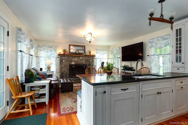 a kitchen with cabinets a sink and a stove with wooden floor