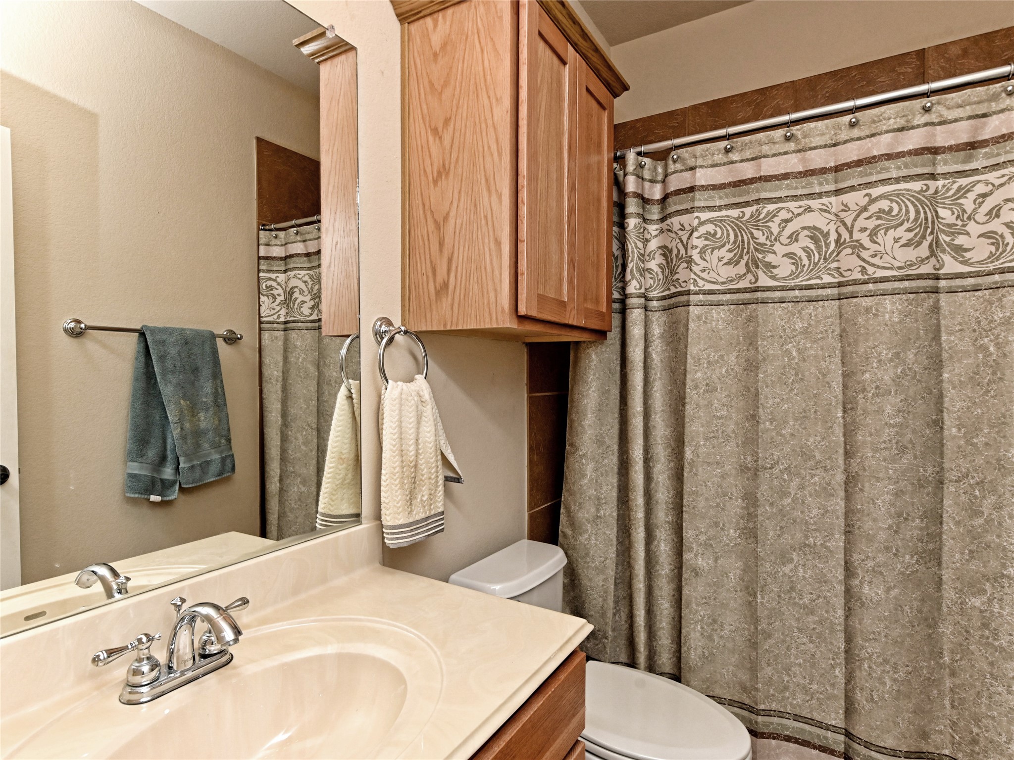 230 Sunrise Ridge Loop Austin, TX 78738 - Photo 25 of 27 Functional full bathroom featuring a practical vanity and a shower-tub combination with a decorative curtain.