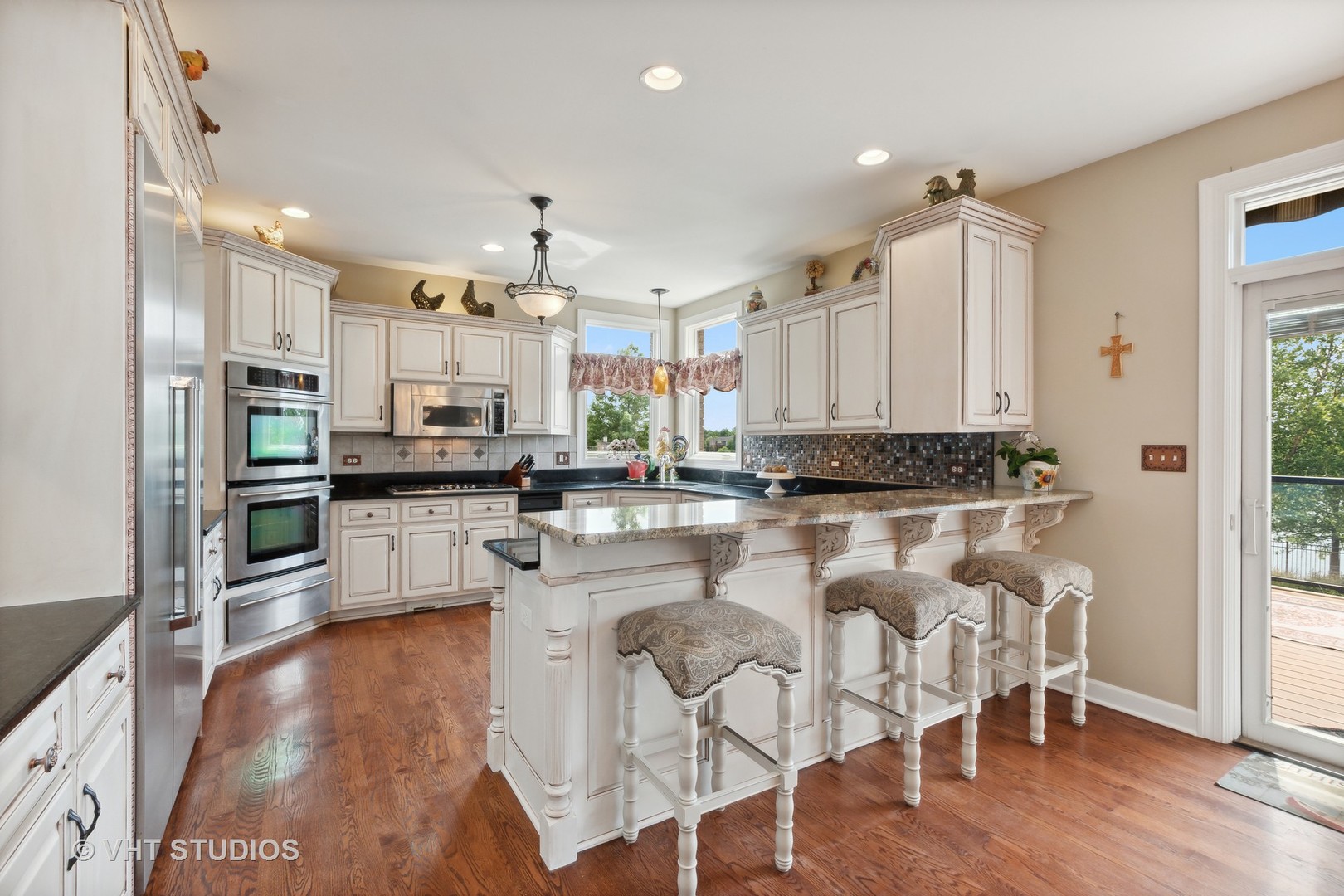 21170 Sage Brush Lane Mokena, IL 60448 - Photo 23 of 66 a kitchen with stainless steel appliances kitchen island granite countertop a refrigerator a stove top oven a sink dishwasher and white cabinets with wooden floor