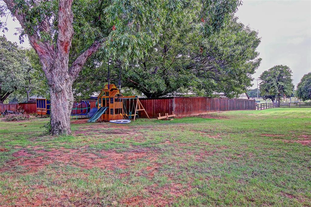 3615 Fritz Lane Corinth, TX 76208 - Photo 24 of 28 a view of a yard with a tree and a wooden fence