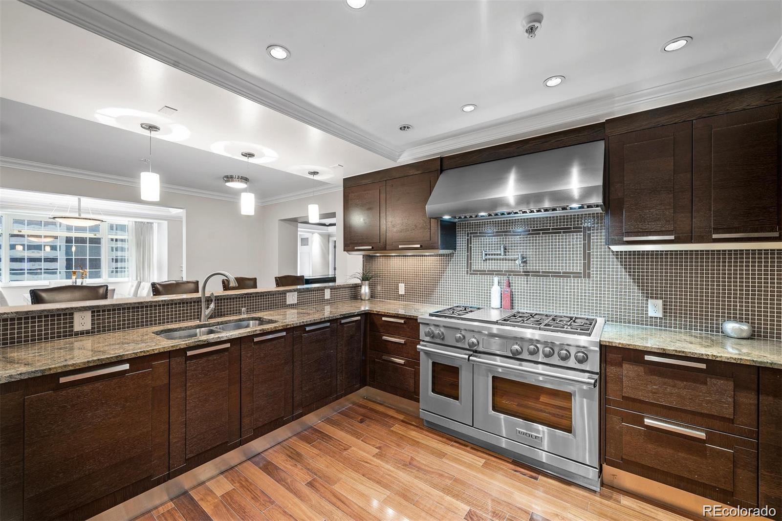 1891 Curtis Street, Unit 1607 Denver, CO 80202 - Photo 13 of 47 a kitchen with stainless steel appliances granite countertop a stove a sink and a microwave
