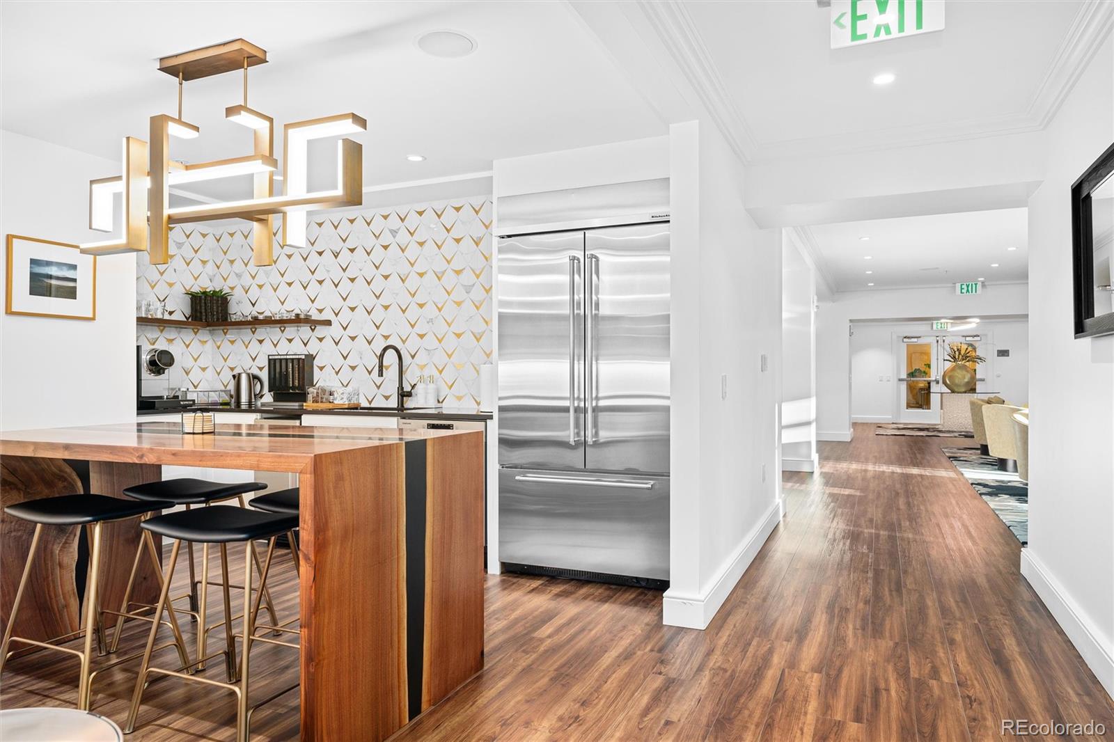 1891 Curtis Street, Unit 1607 Denver, CO 80202 - Photo 39 of 47 a kitchen with stainless steel appliances granite countertop a refrigerator a sink dishwasher a stove and white countertops with wooden floor