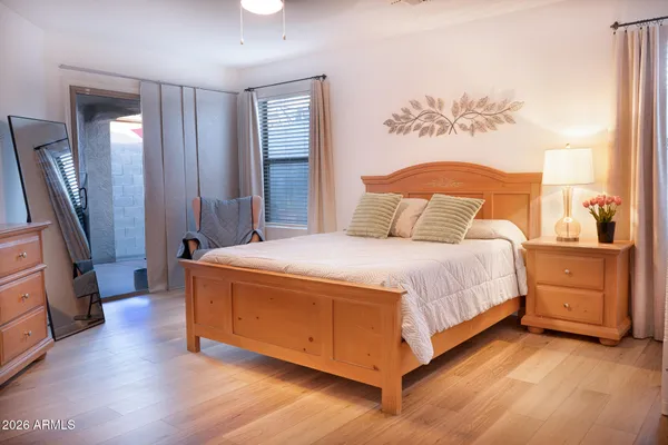 a spacious bedroom with a bed and a dresser