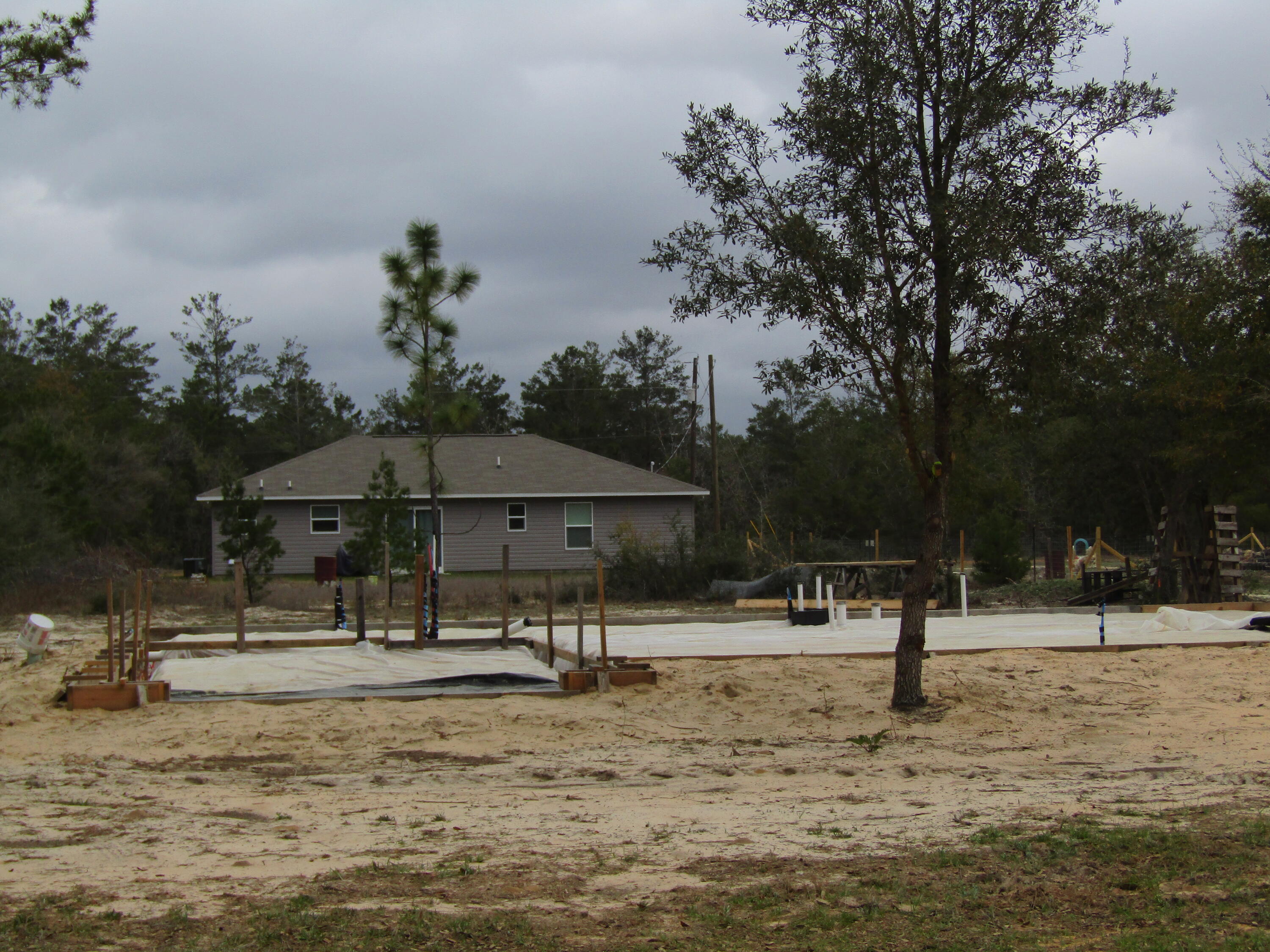 331 Passion Flower Street DeFuniak Springs, FL 32433 - Photo 2 of 5 a view of a park with swings and a bench