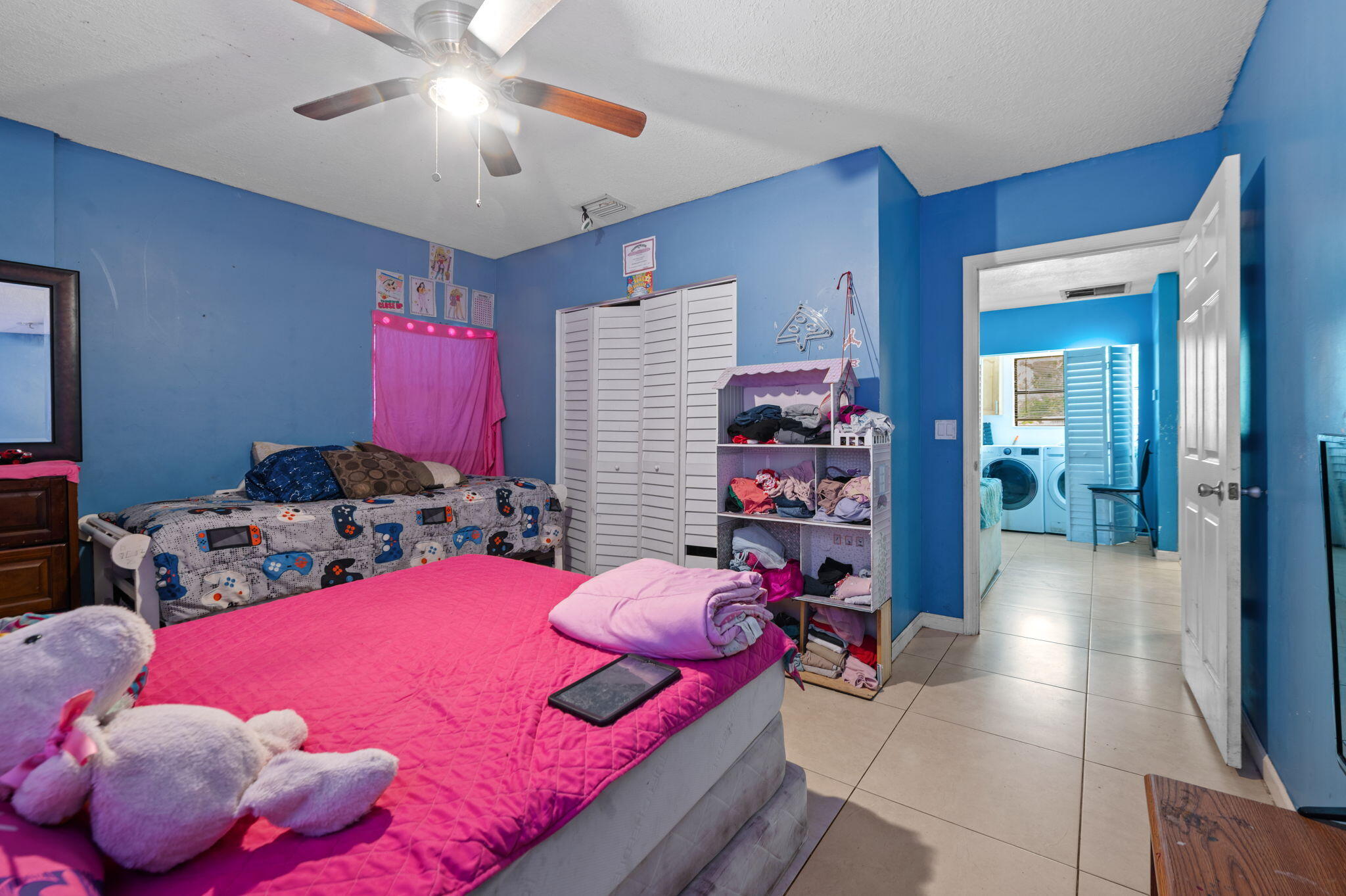 2587 E Road Loxahatchee Groves, FL 33470 - Photo 21 of 46 a bedroom with a bed and a chandelier