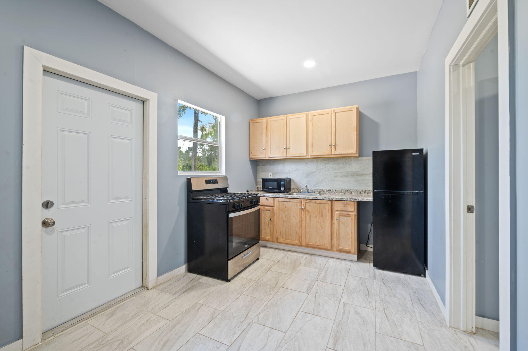 2587 E Road Loxahatchee Groves, FL 33470 - Photo 28 of 46 a kitchen with a refrigerator and window
