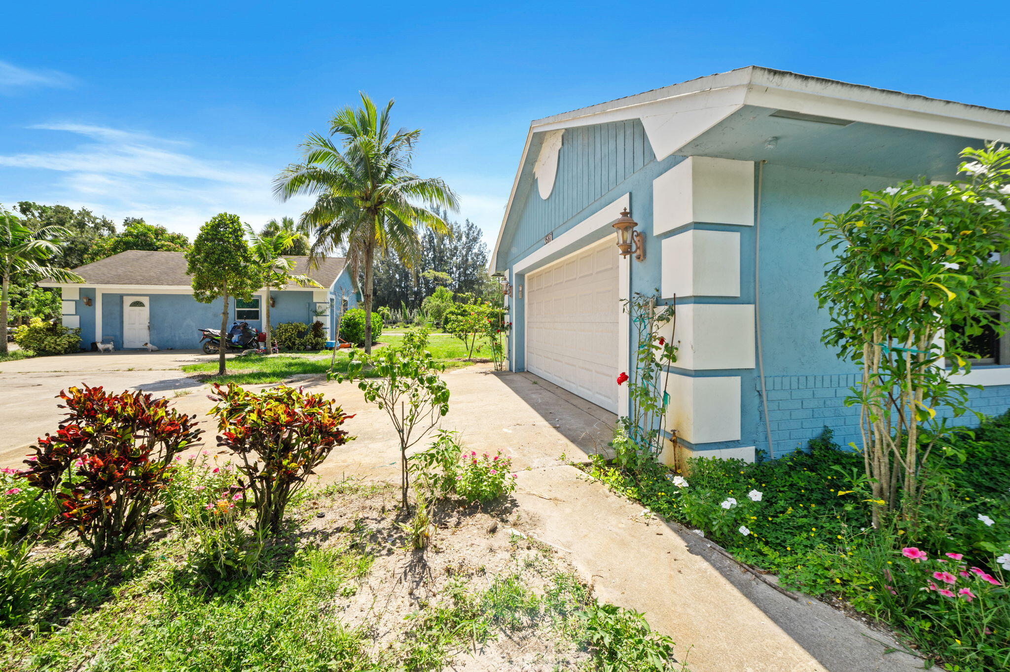 2587 E Road Loxahatchee Groves, FL 33470 - Photo 3 of 46 a front view of a house with garden