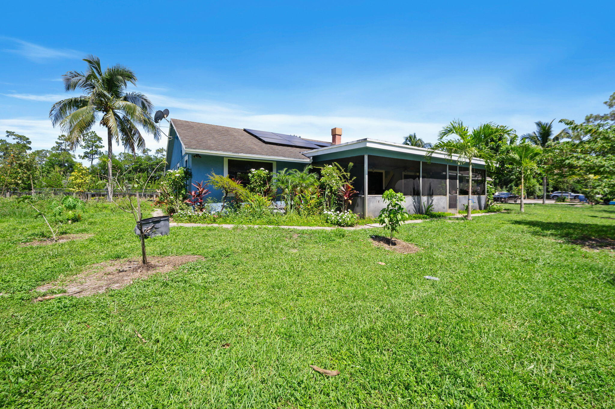2587 E Road Loxahatchee Groves, FL 33470 - Photo 32 of 46 a front view of a house with a yard and potted plants