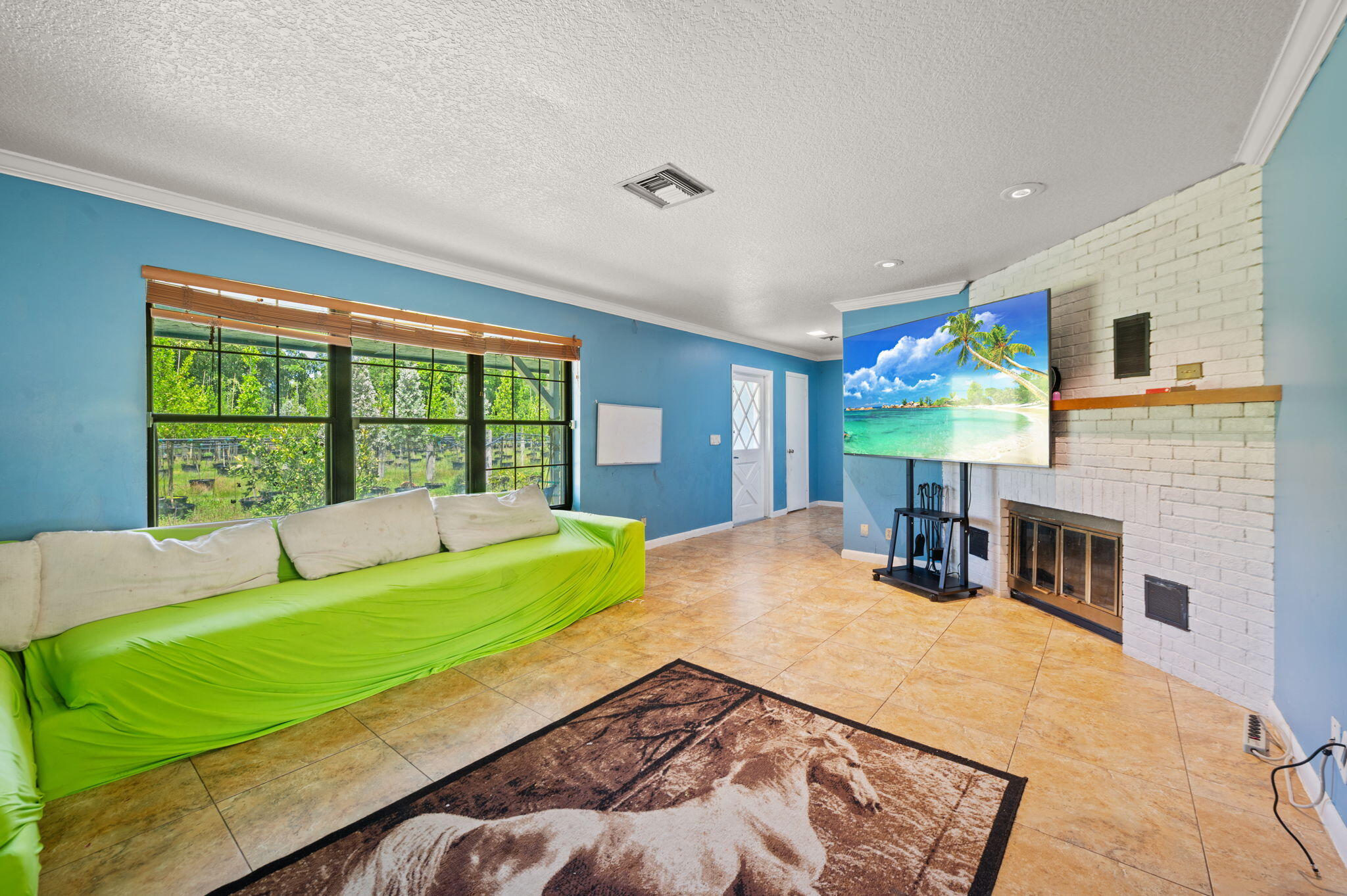 2587 E Road Loxahatchee Groves, FL 33470 - Photo 7 of 46 a bed sitting in a bedroom and table next to a window