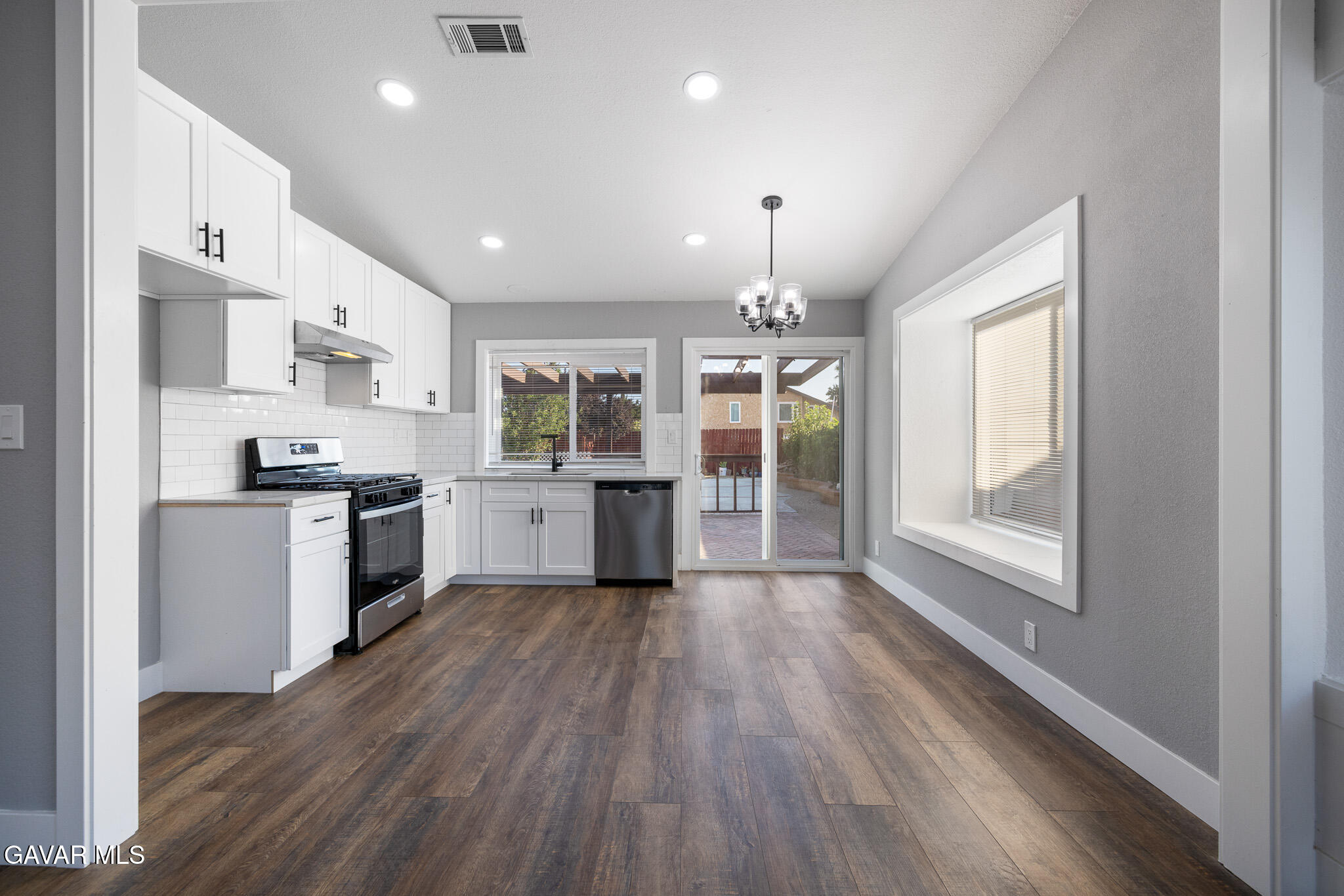 4753 East Ave R 11 Palmdale, CA 93552 - Photo 11 of 41 a kitchen with stainless steel appliances granite countertop a refrigerator a sink dishwasher a stove and white countertops with wooden floor