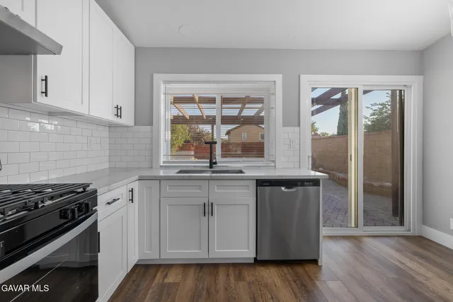a kitchen with granite countertop wooden cabinets stainless steel appliances and a window