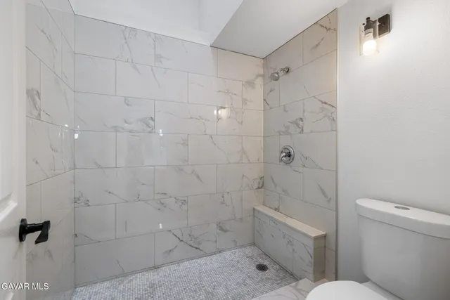 a bathroom with a toilet and shower