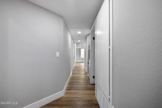 a view of a hallway with wooden floor