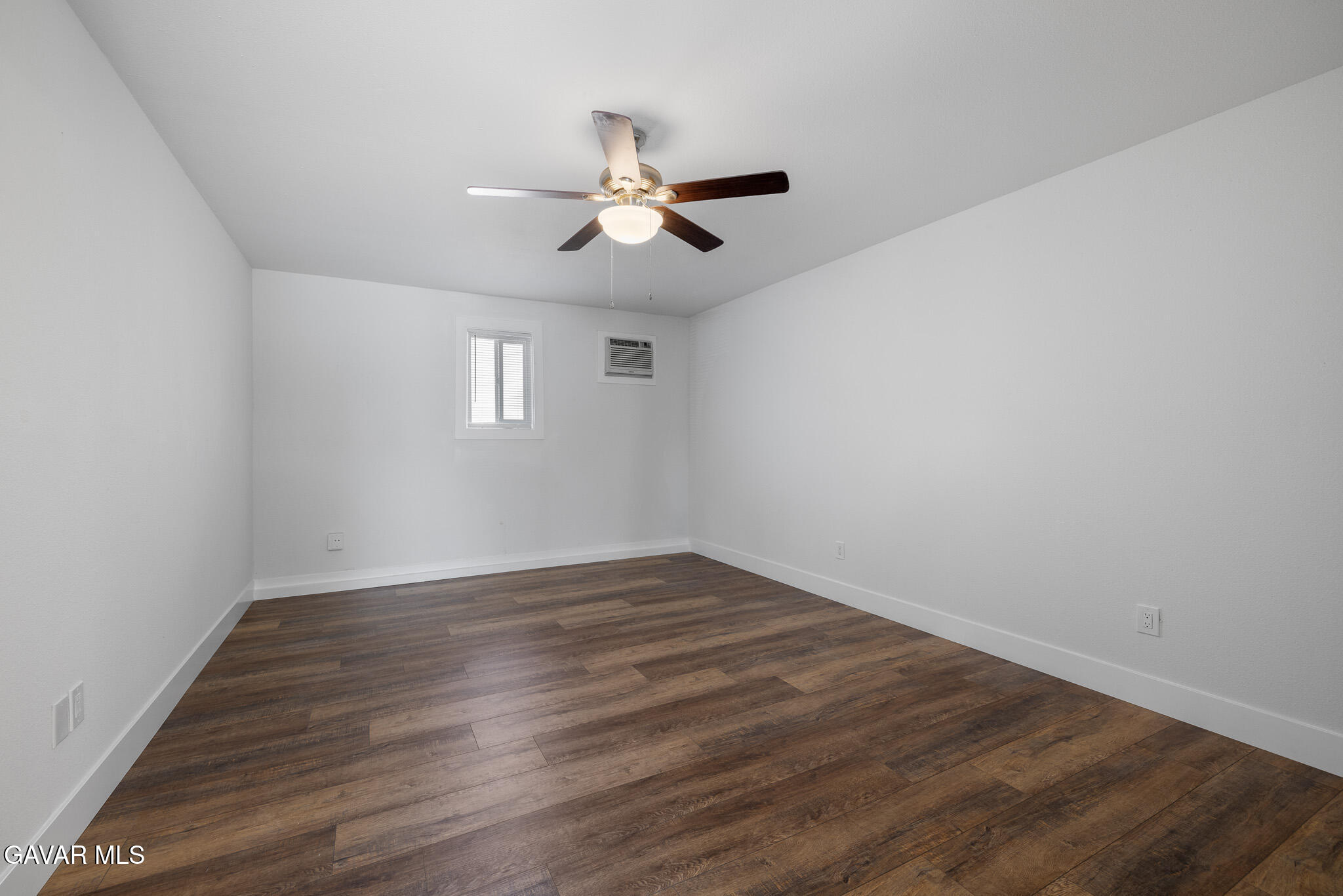 4753 East Ave R 11 Palmdale, CA 93552 - Photo 31 of 41 an empty room with wooden floor ceiling fan and windows