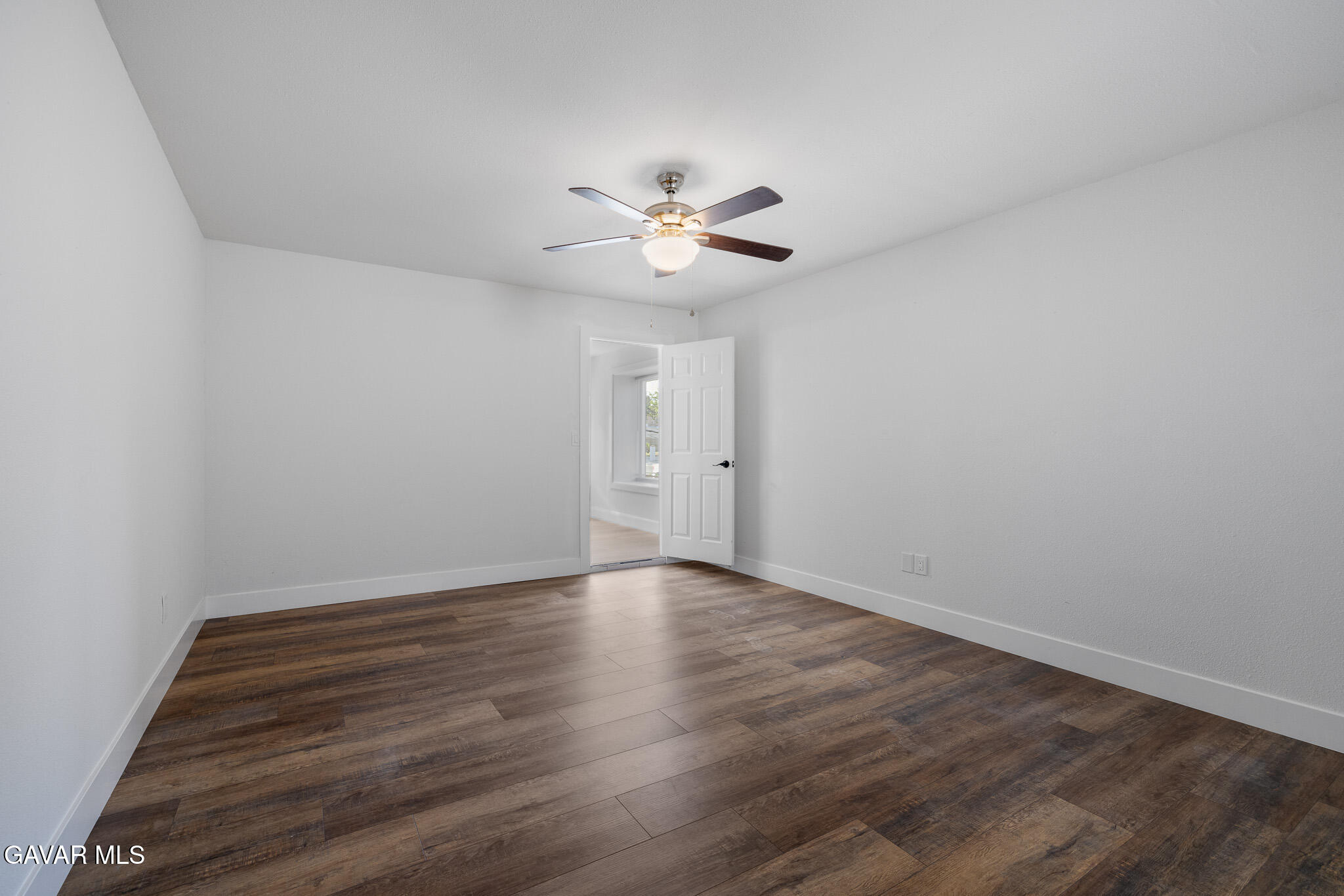 4753 East Ave R 11 Palmdale, CA 93552 - Photo 32 of 41 a view of an empty room with a ceiling fan and wooden floor