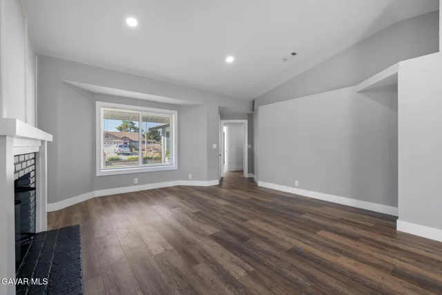an empty room with wooden floor and a window