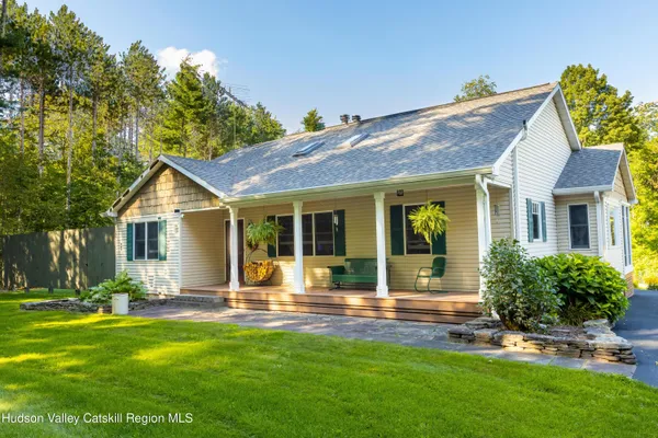 a view of a house with backyard and sitting area
