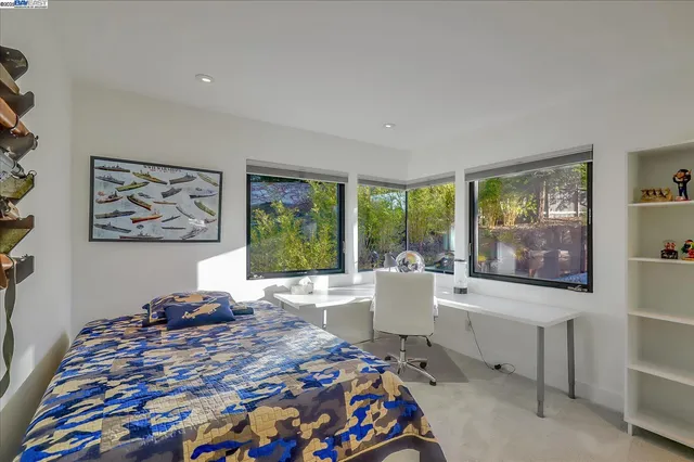 a bed sitting in a bedroom next to a window